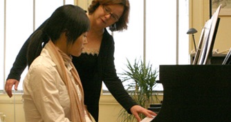 Licensed Andover Educator Lisa Marsh works with a student at the piano.